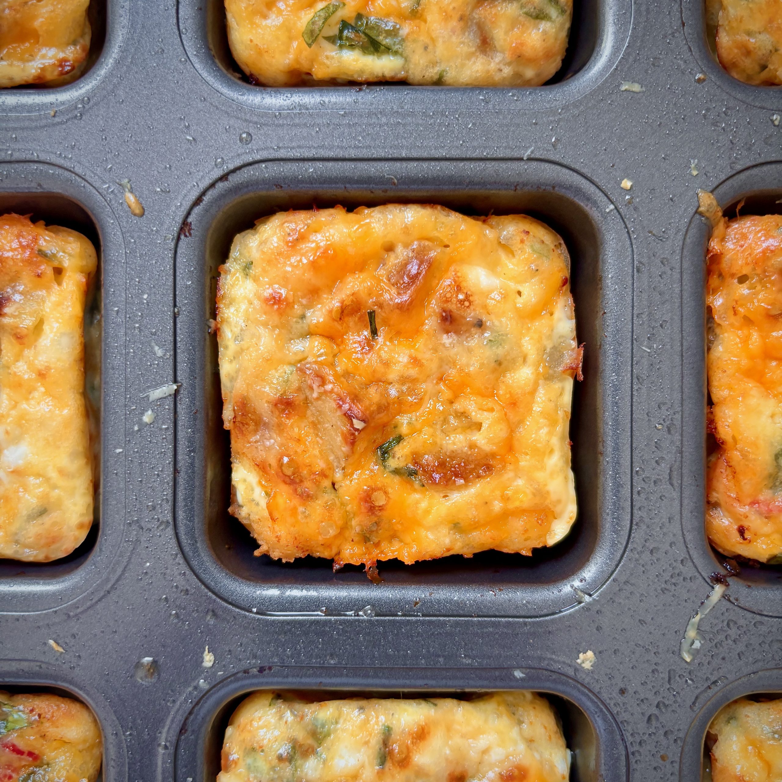 Golden cheesy veggie egg bites in tin