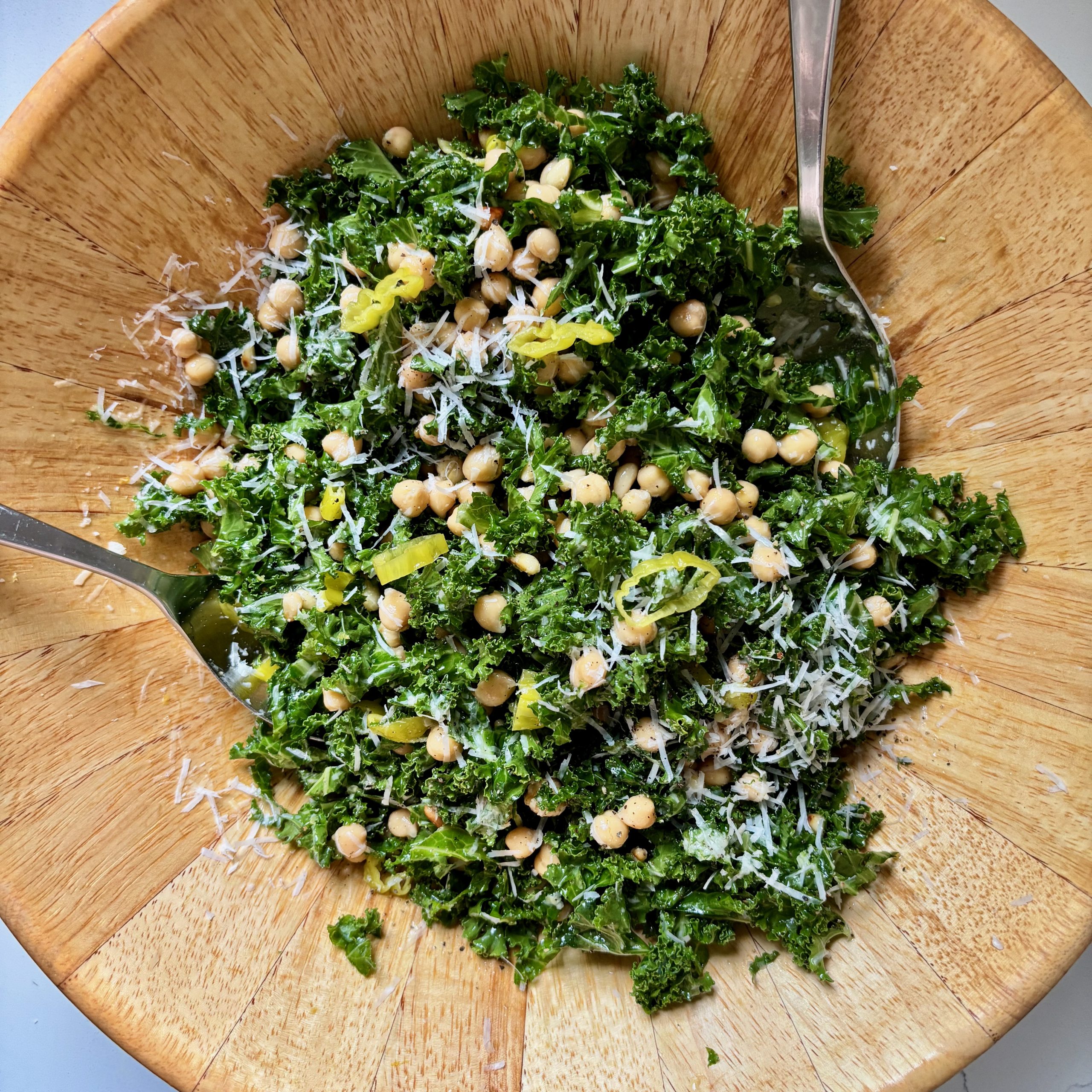 Overhead shot of large bowl with kale and chickpea salad with parmesan cheese and lemon