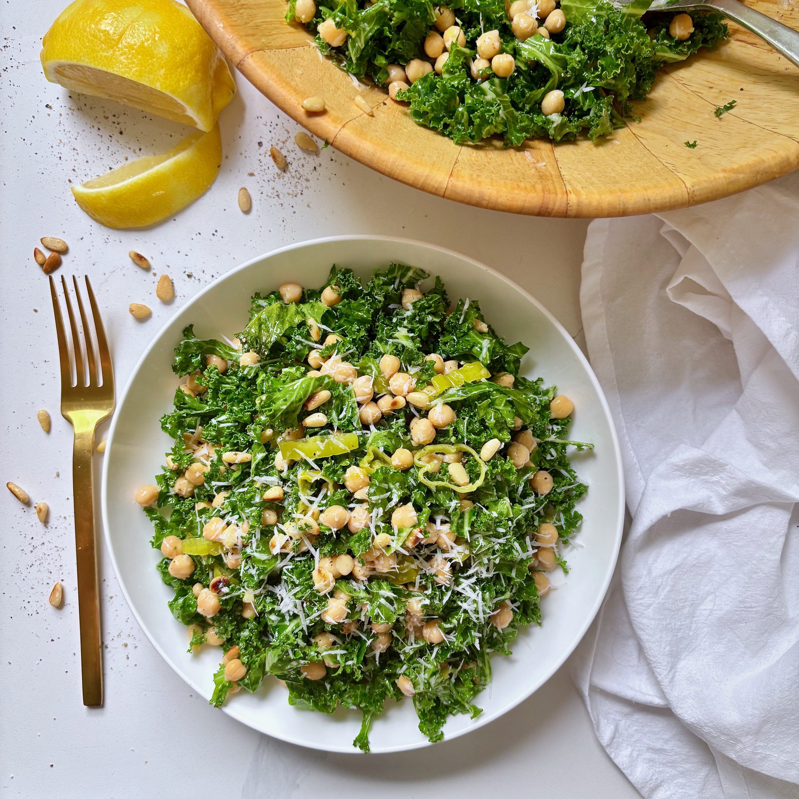 Bowl of kale and chickpea salad topped with crispy panko crumbs and parmesan