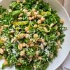 Bowl of kale salad with chickpeas, pepperoncini, and lemon parmesan dressing