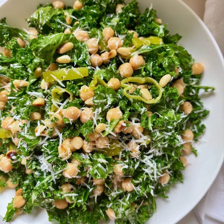 Bowl of kale salad with chickpeas, pepperoncini, and lemon parmesan dressing
