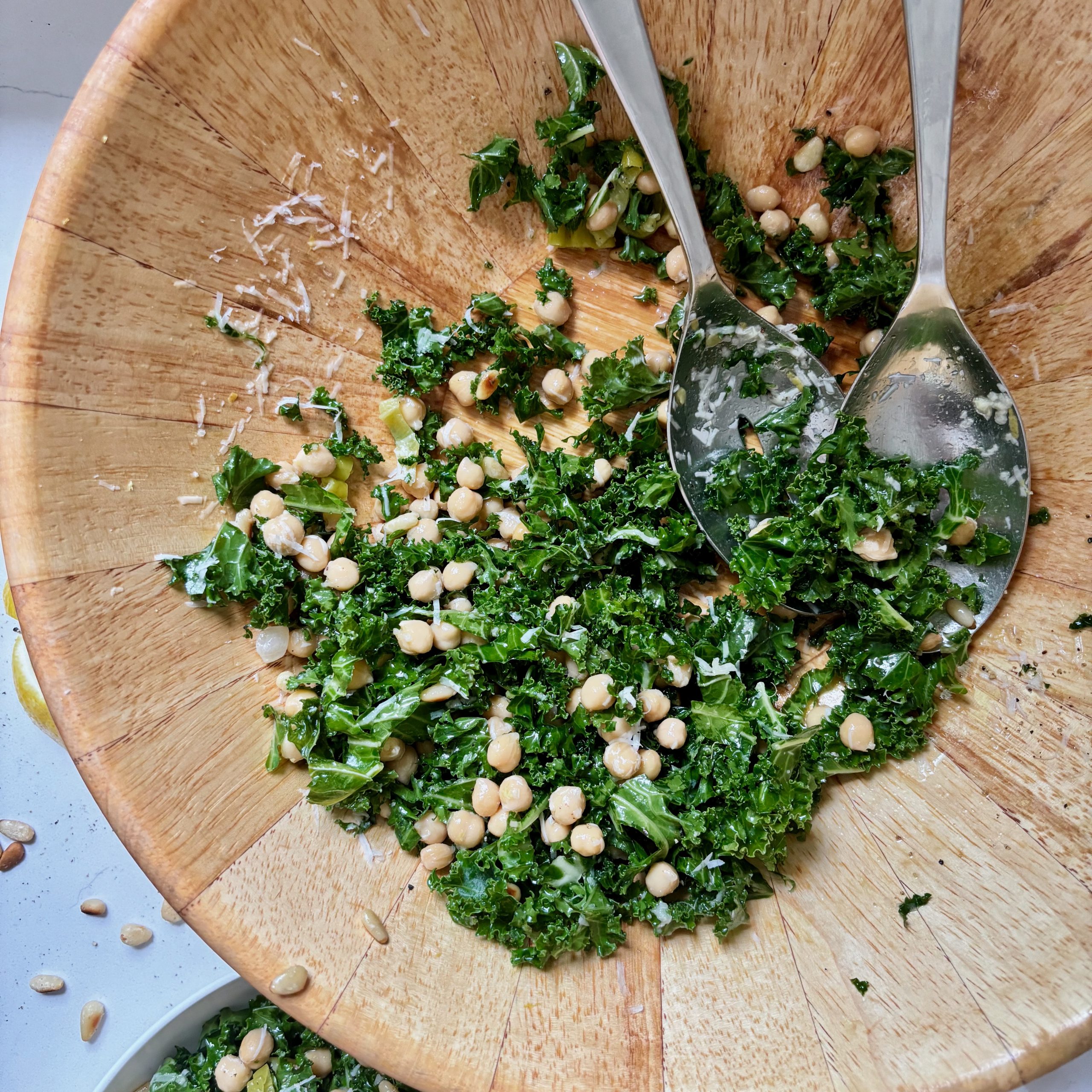 Serving bowl with kale and chickpea salad with parmesan cheese and lemon