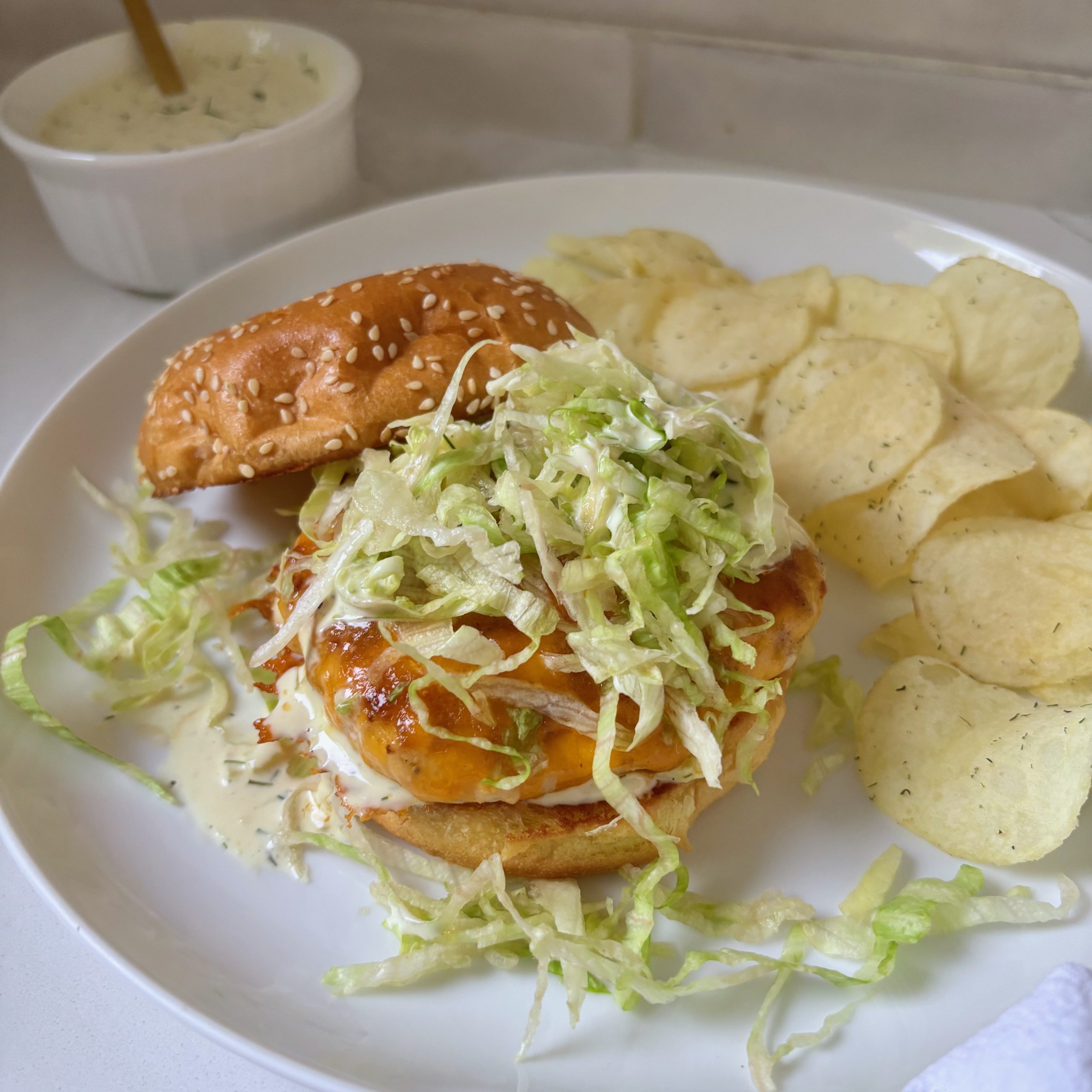 Burger assembly with bun, lettuce, cheddar turkey patty, and sauce