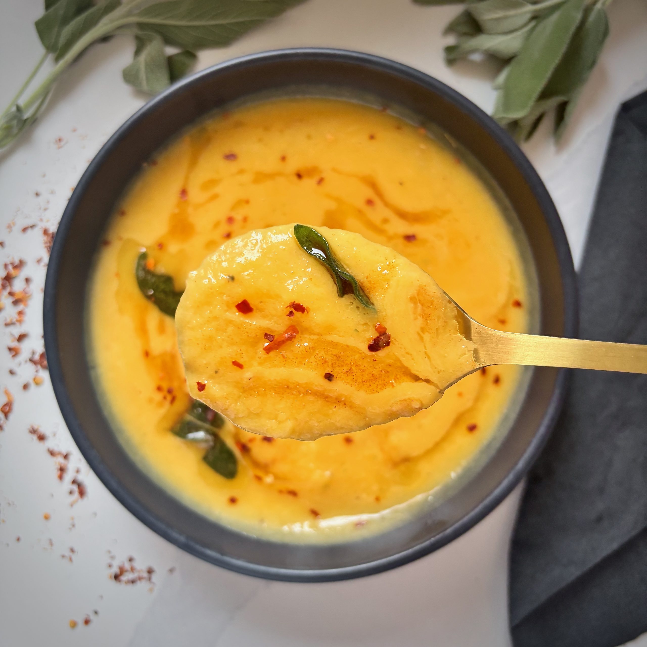 Close up of Butternut squash soup with crispy sage and red pepper flakes