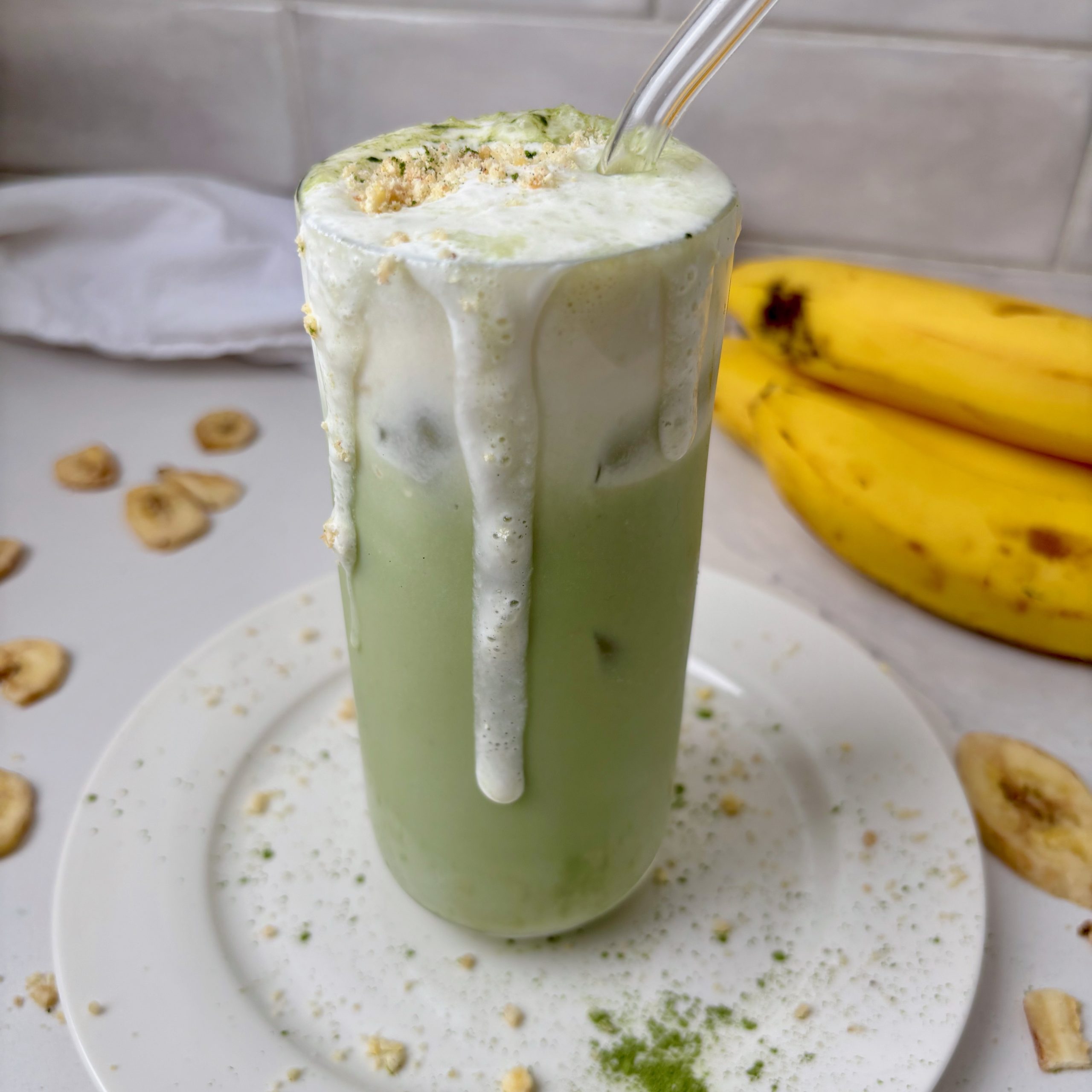 Banana Cream Matcha in glass with cold foam dripping