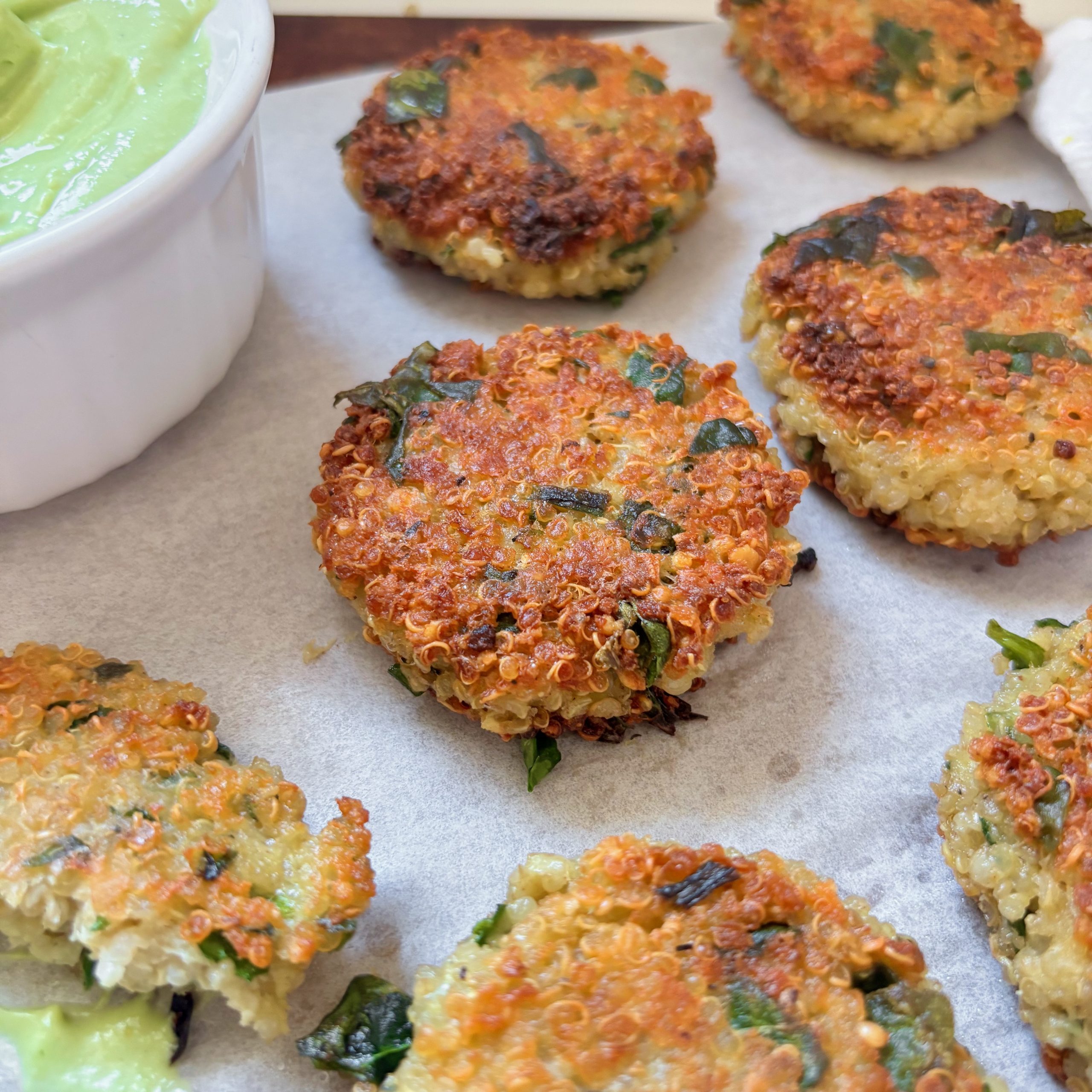 Pan-fried spinach quinoa bites with creamy avocado feta dip
