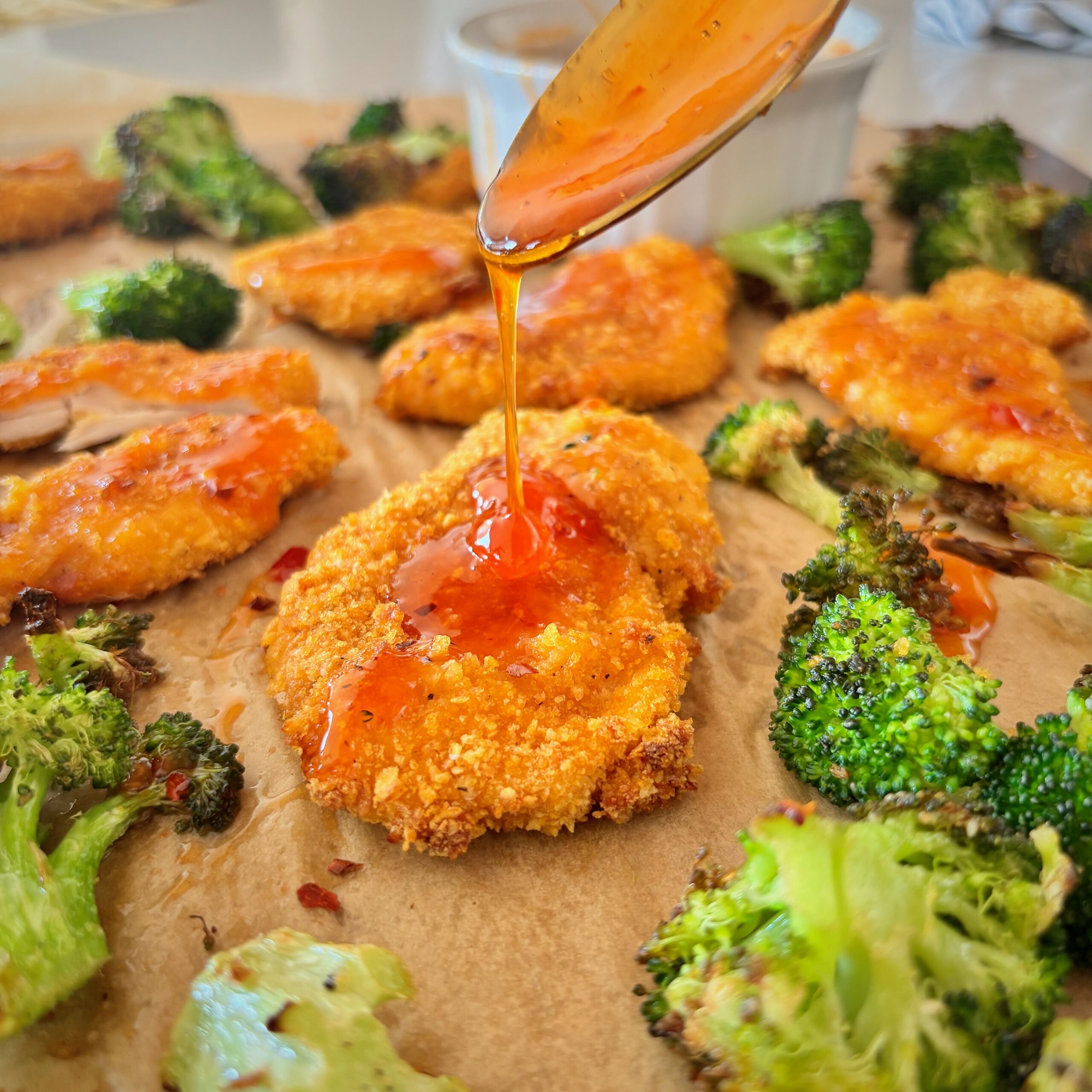 Cornflake chicken strips drizzled with sweet chili honey served with roasted broccoli