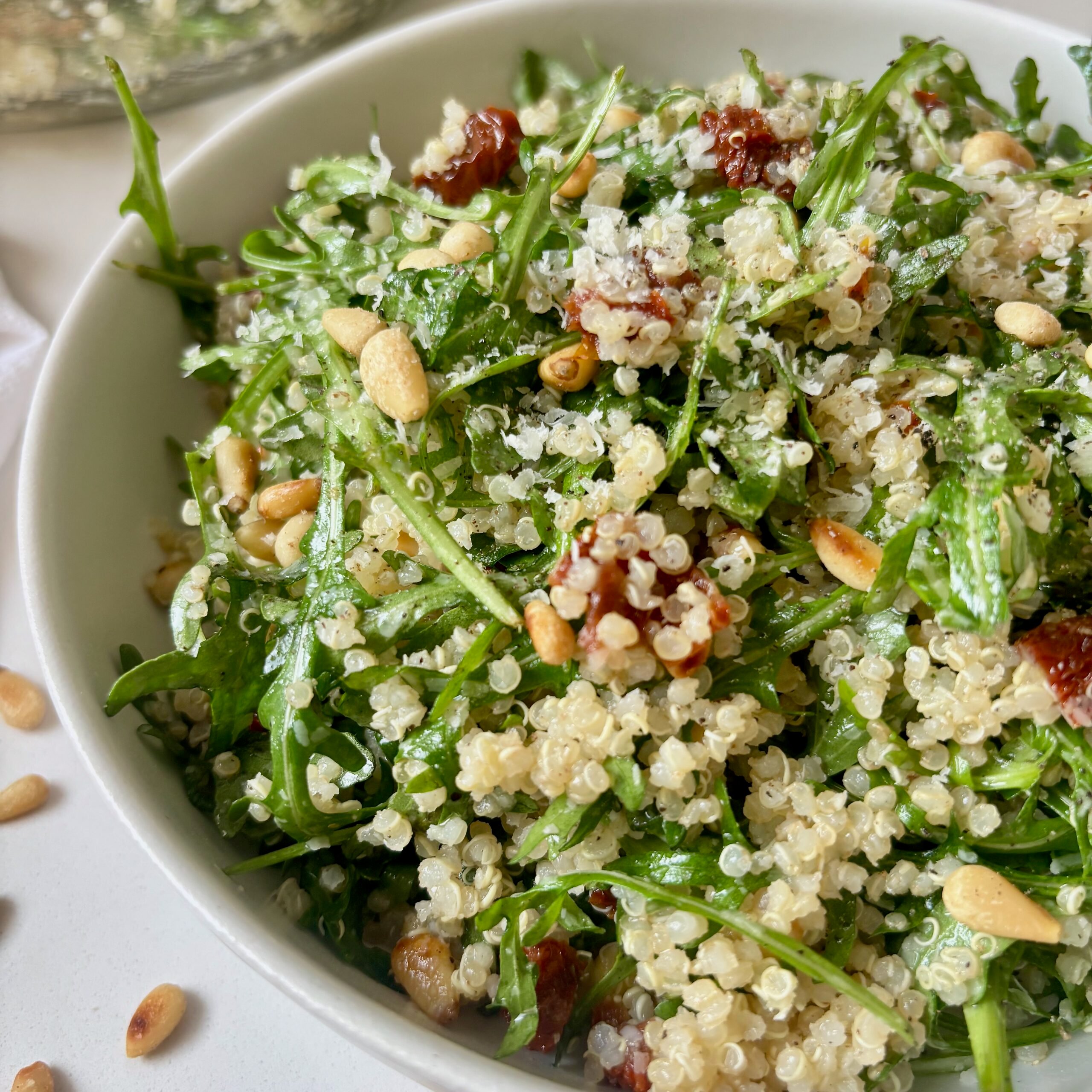 Close up of arugula and quinoa salad tossed in lemon dressing