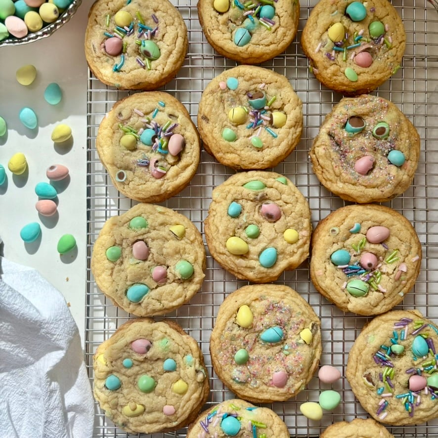 Freshly baked mini egg cookies on a cooling rack with golden edges