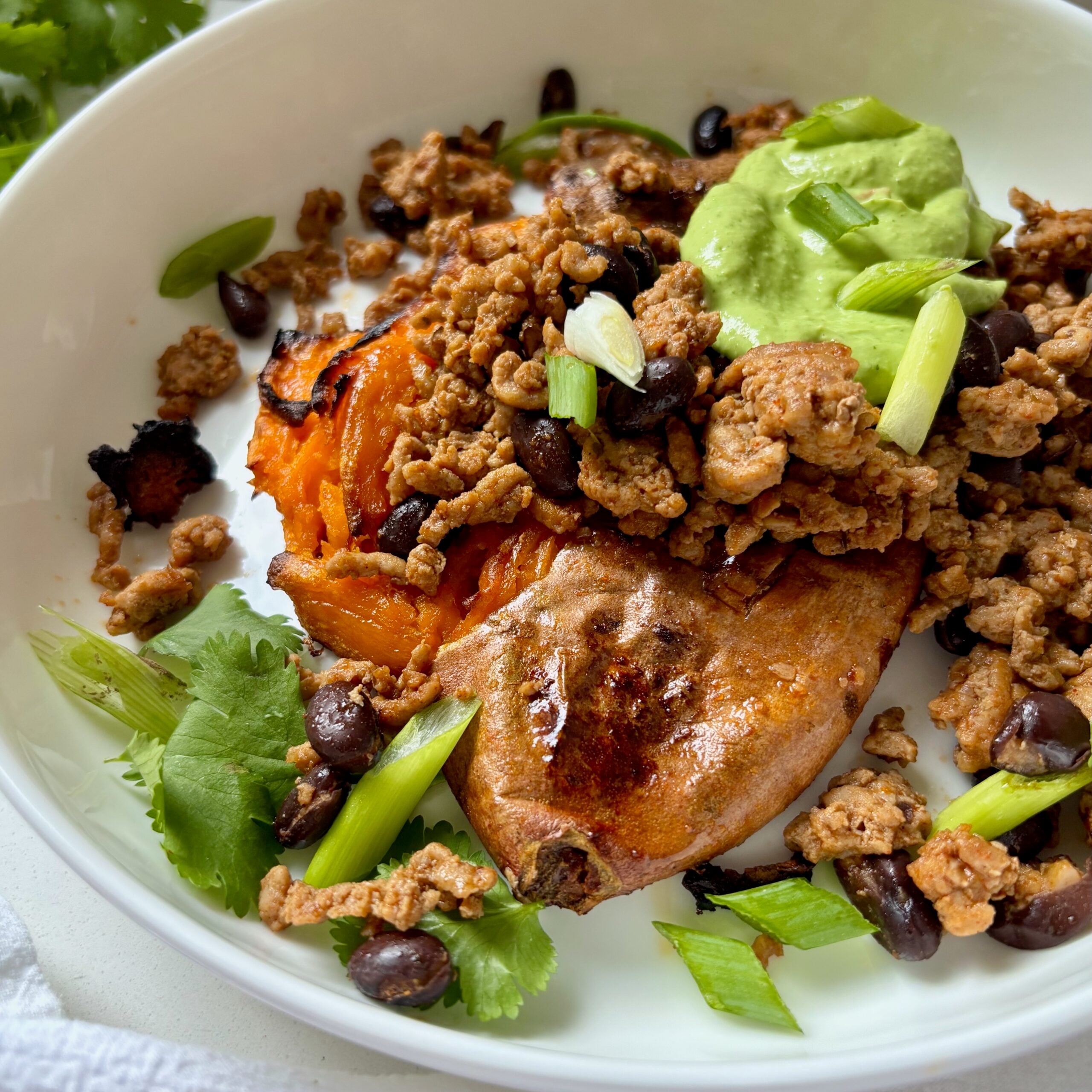 Smashed and loaded sweet potatoes topped with spiced ground turkey, black beans, and creamy green sauce.