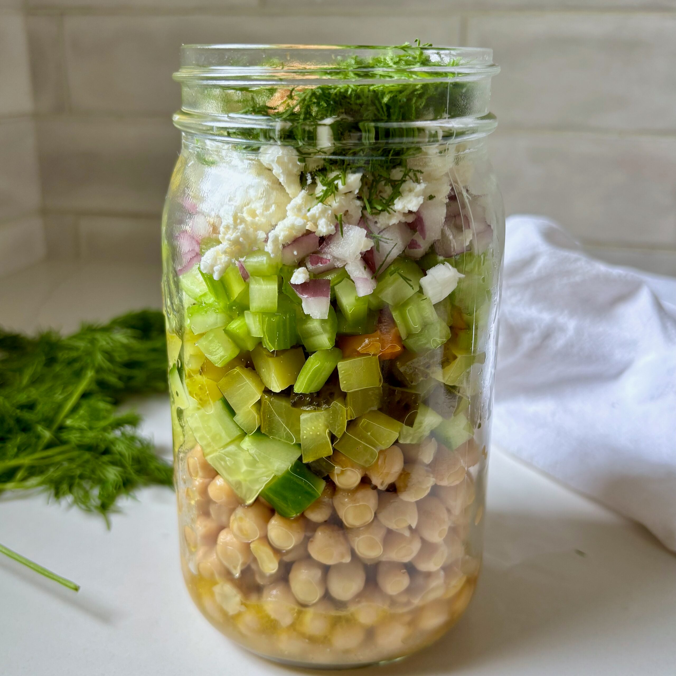 Spicy Dill Pickle Marinated Chickpea Jars with feta and pickle brine dressing.