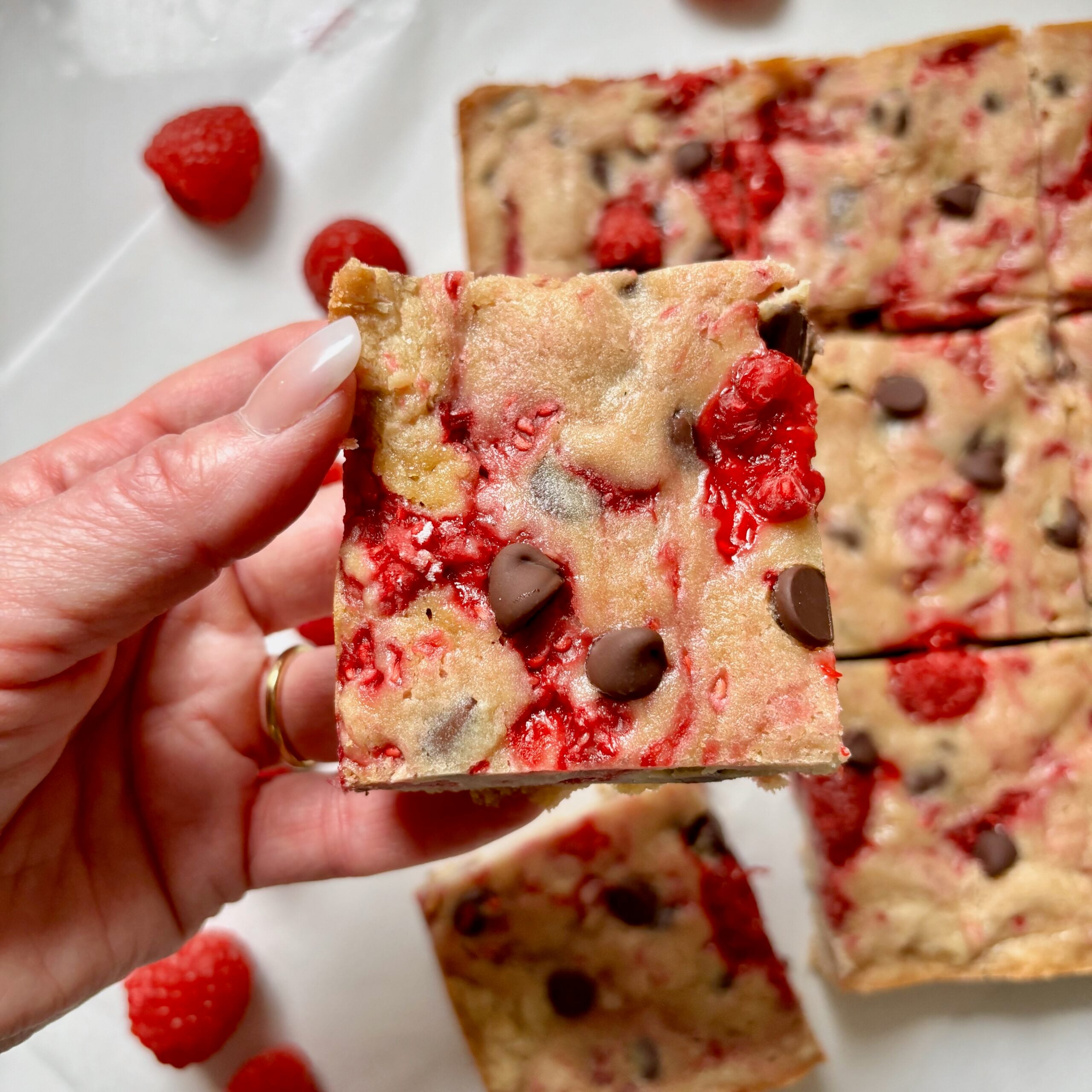 Fudgy dark chocolate raspberry blondies with melted chocolate and raspberries.