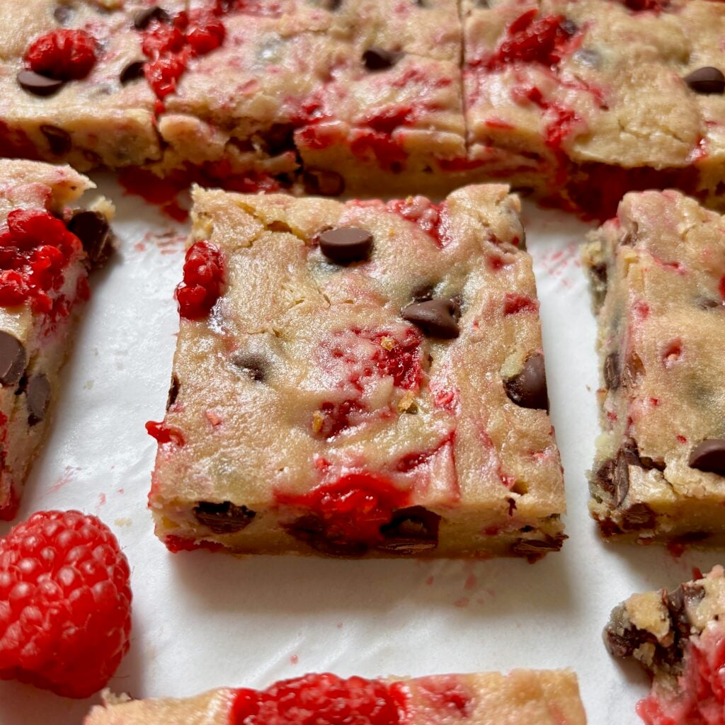 Close-up of a raspberry blondie showing its fudgy texture.