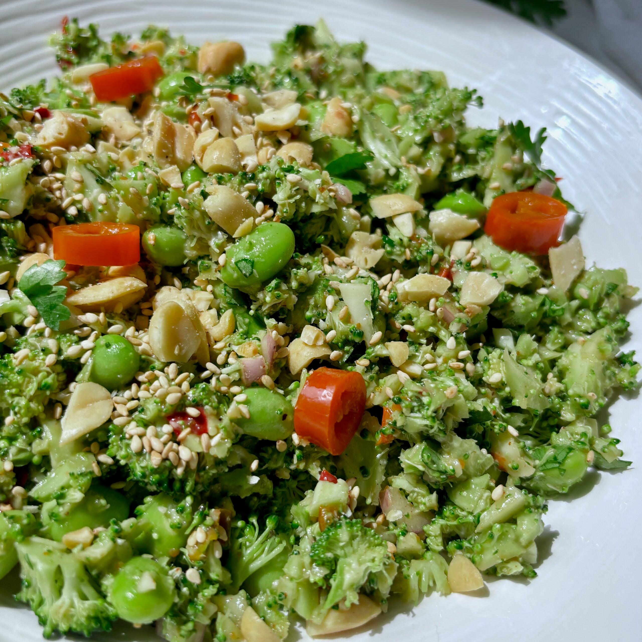 Close-up of finely chopped broccoli salad with edamame, peanuts, and cilantro.
