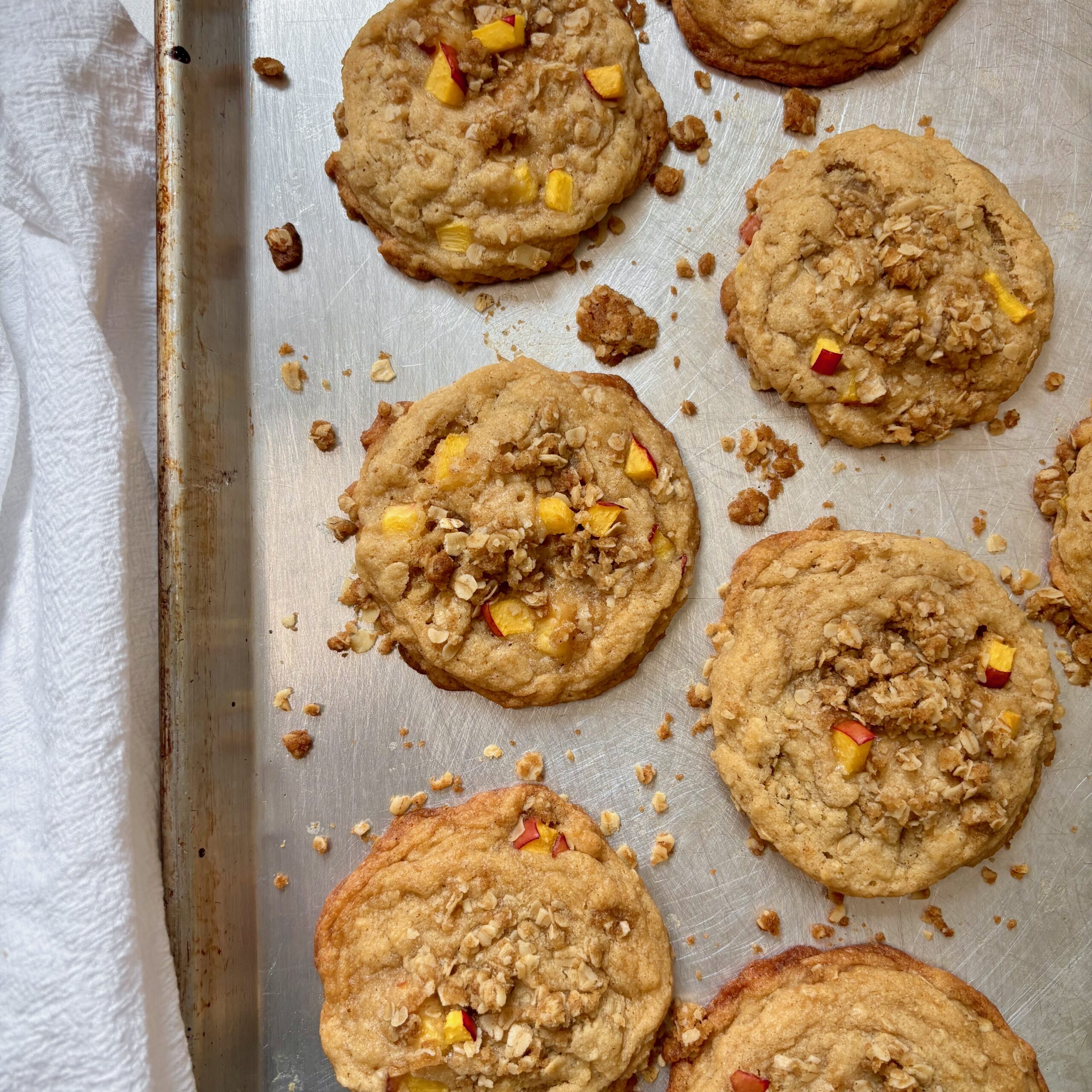 Homemade peach crisp cookies on a baking sheet with crumble topping