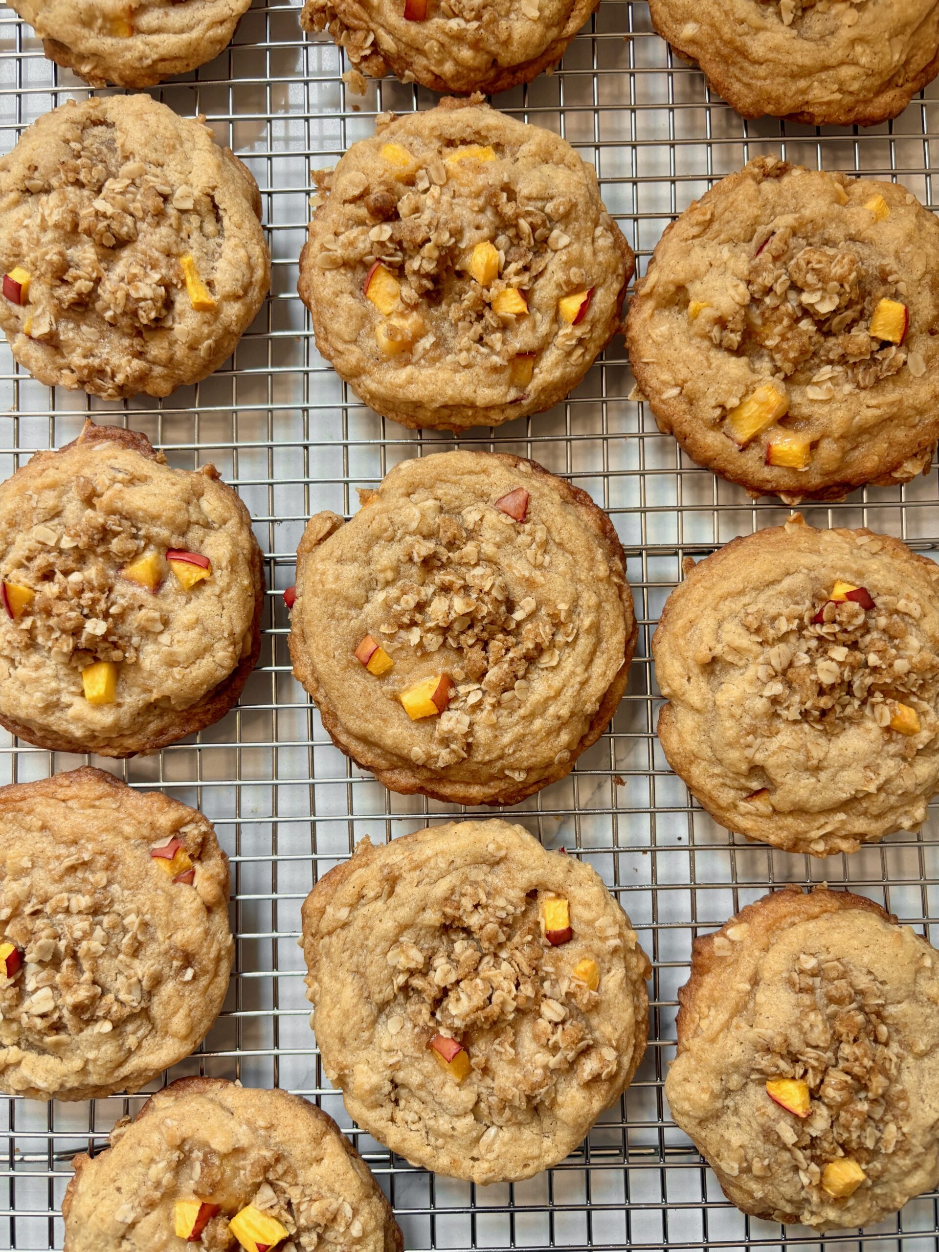 Homemade peach crisp cookies on a baking rack after baking