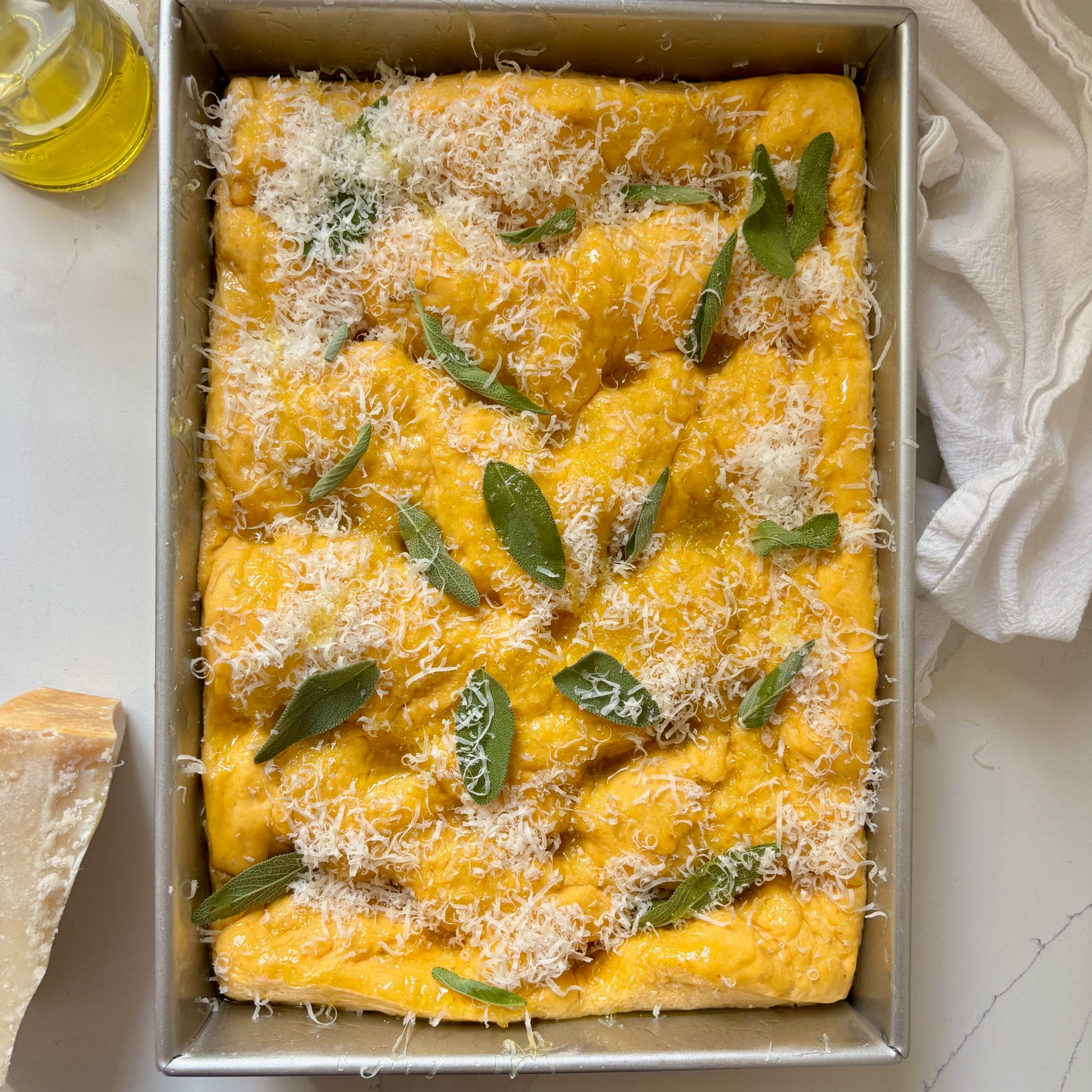 Pumpkin focaccia dough with crispy sage and Parmesan in a 9×13-inch pan