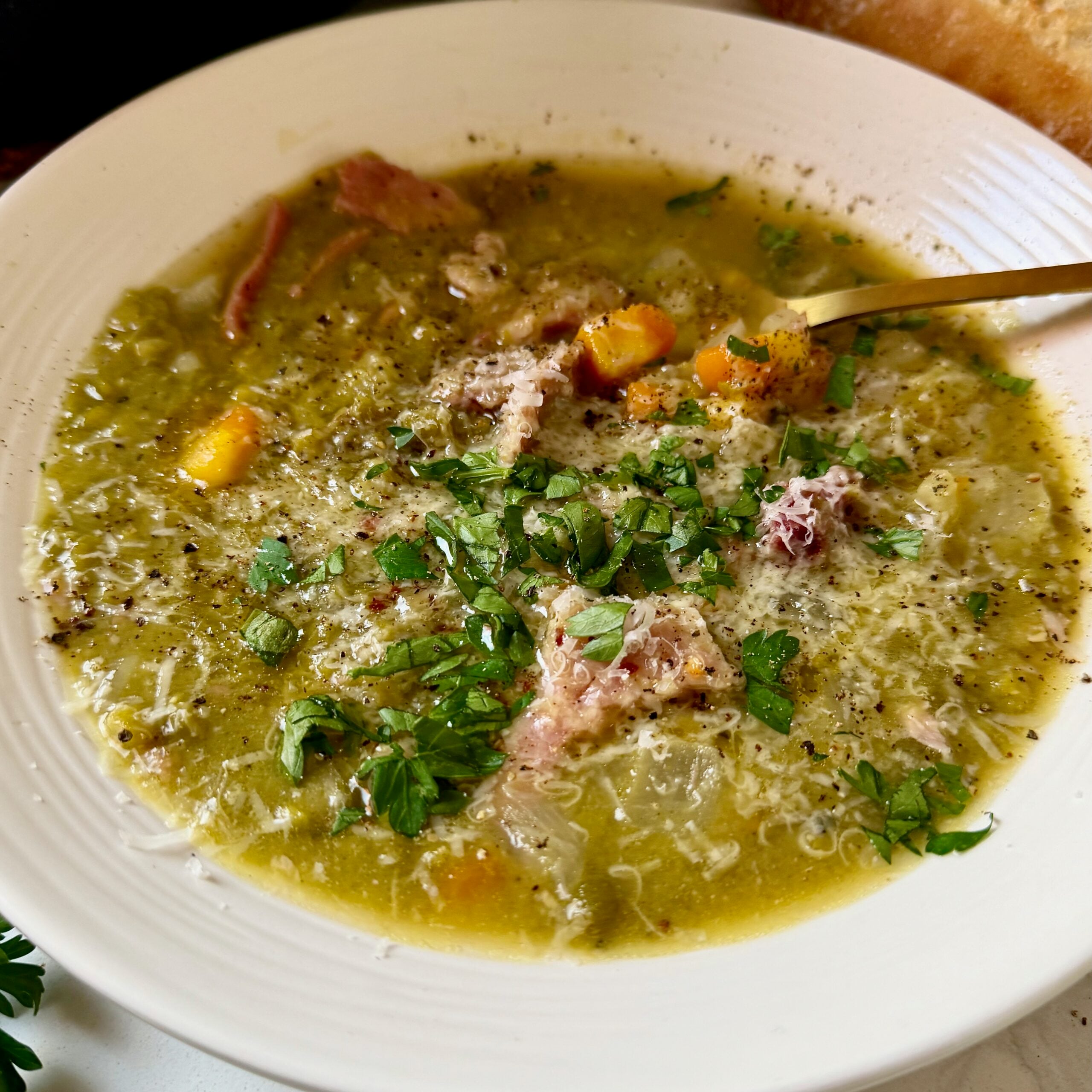 Thick green split pea soup with shredded ham and a drizzle of spicy garlic butter.