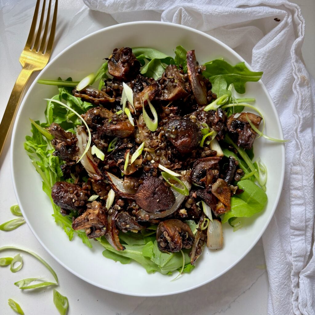 Roasted mushrooms and black lentils with garlic miso butter, lemon zest and sliced green onions.