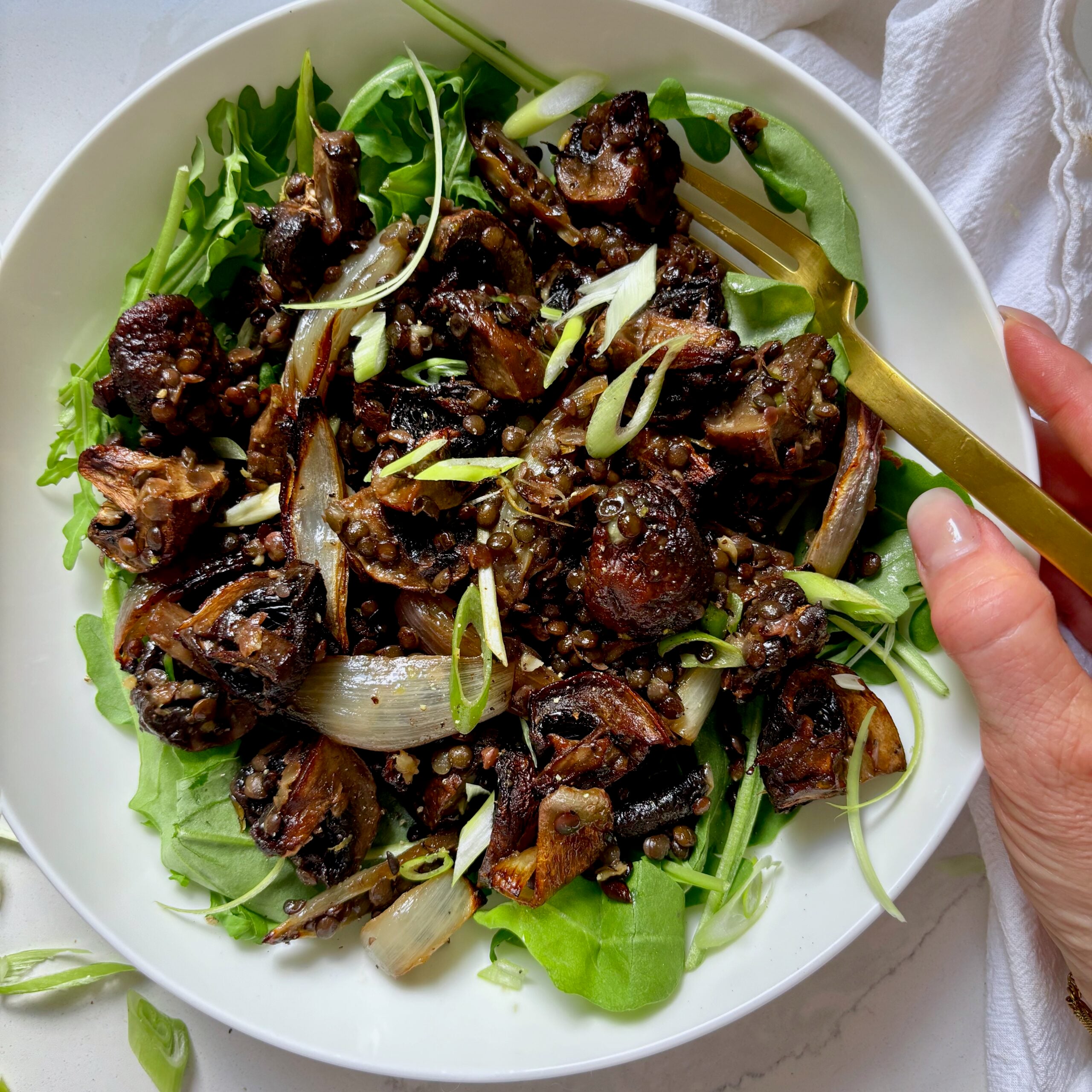 Crispy lentils and roasted mushrooms served in a bowl with garlicky miso butter and fresh green onions.